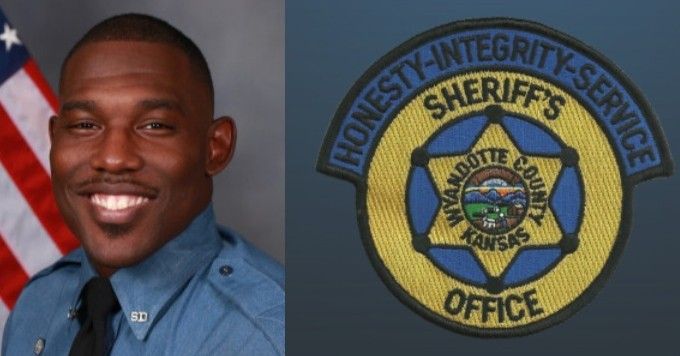 Wyandotte County Sheriff, Black man, smiling with sheriff's office patch, American flag background.