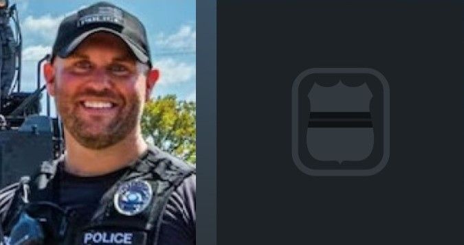 A man in a police uniform is smiling for the camera.