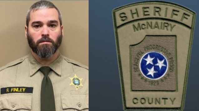 A man with a beard is wearing a sheriff 's uniform and tie.