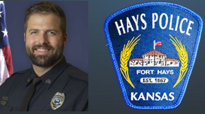 Officer in uniform, Hays Police, Kansas. Smiling, next to police patch with wheat stalks and fort.