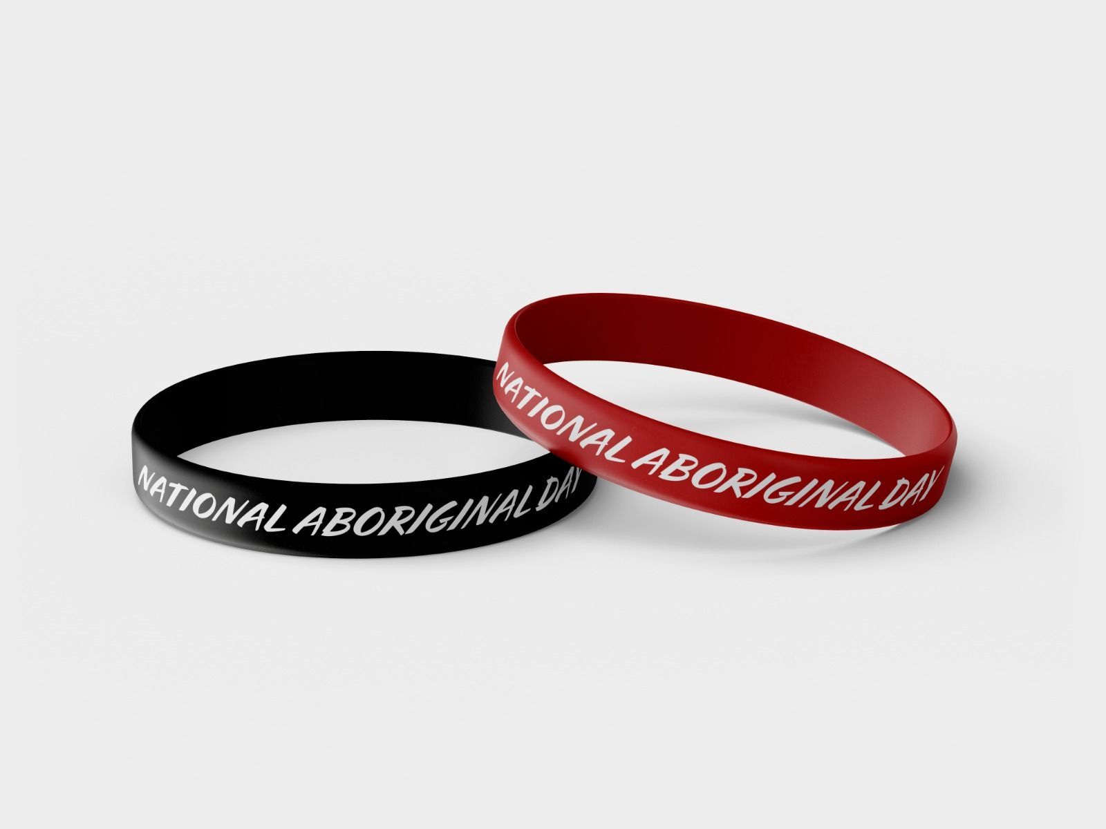 Two bracelets are sitting next to each other on a white surface.