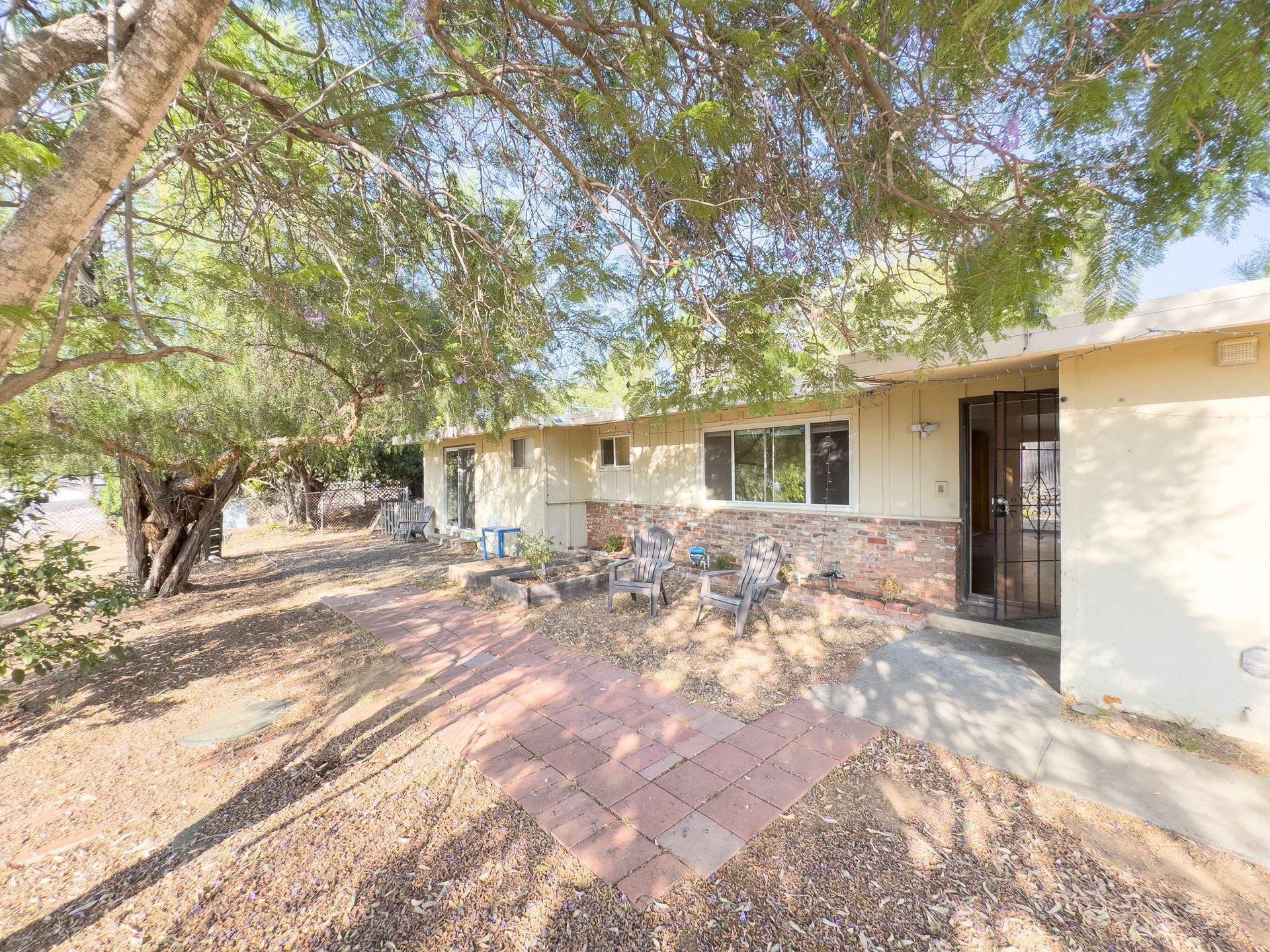 A house with a patio and trees in front of it.