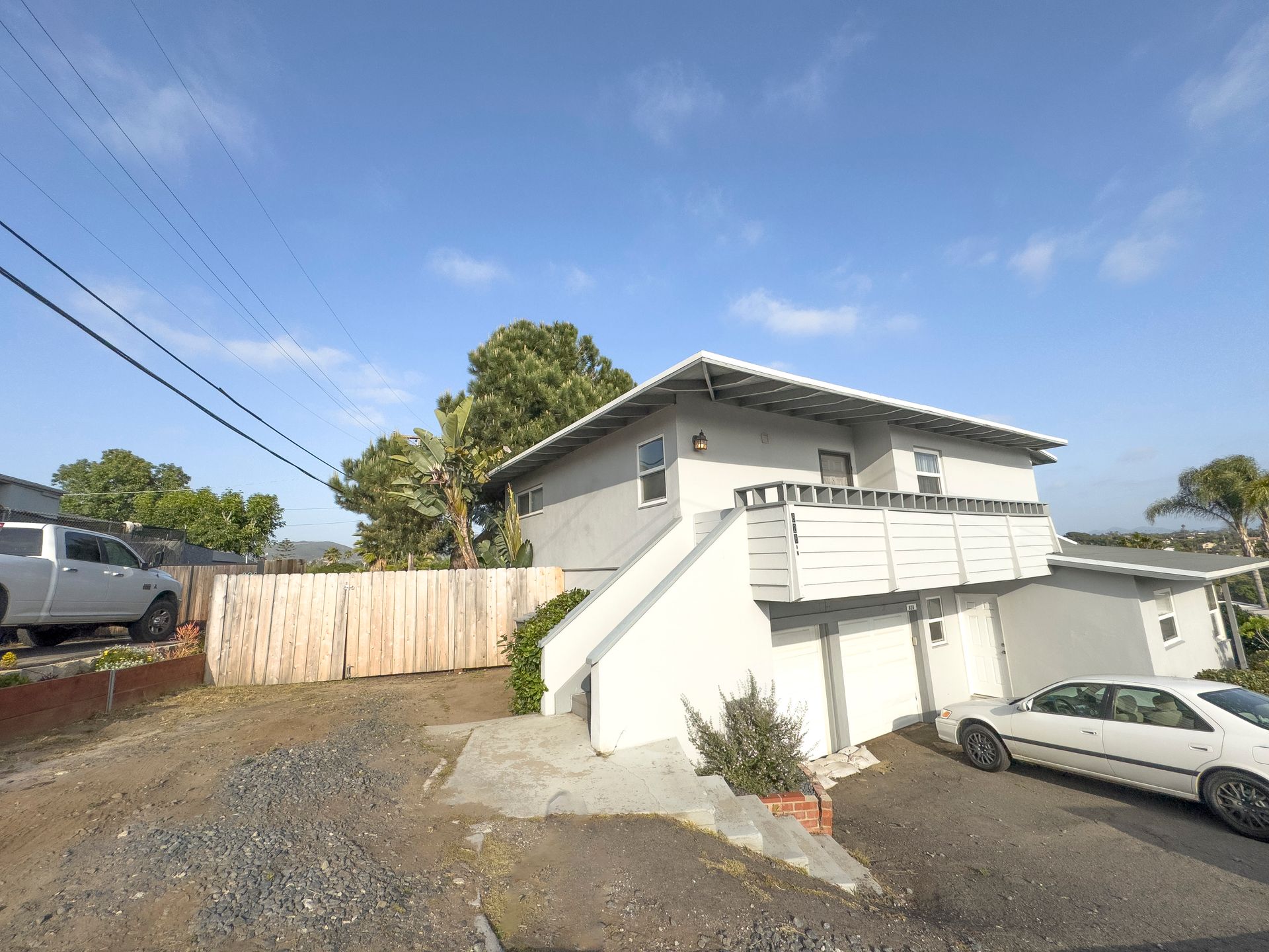 A white car is parked in front of a house