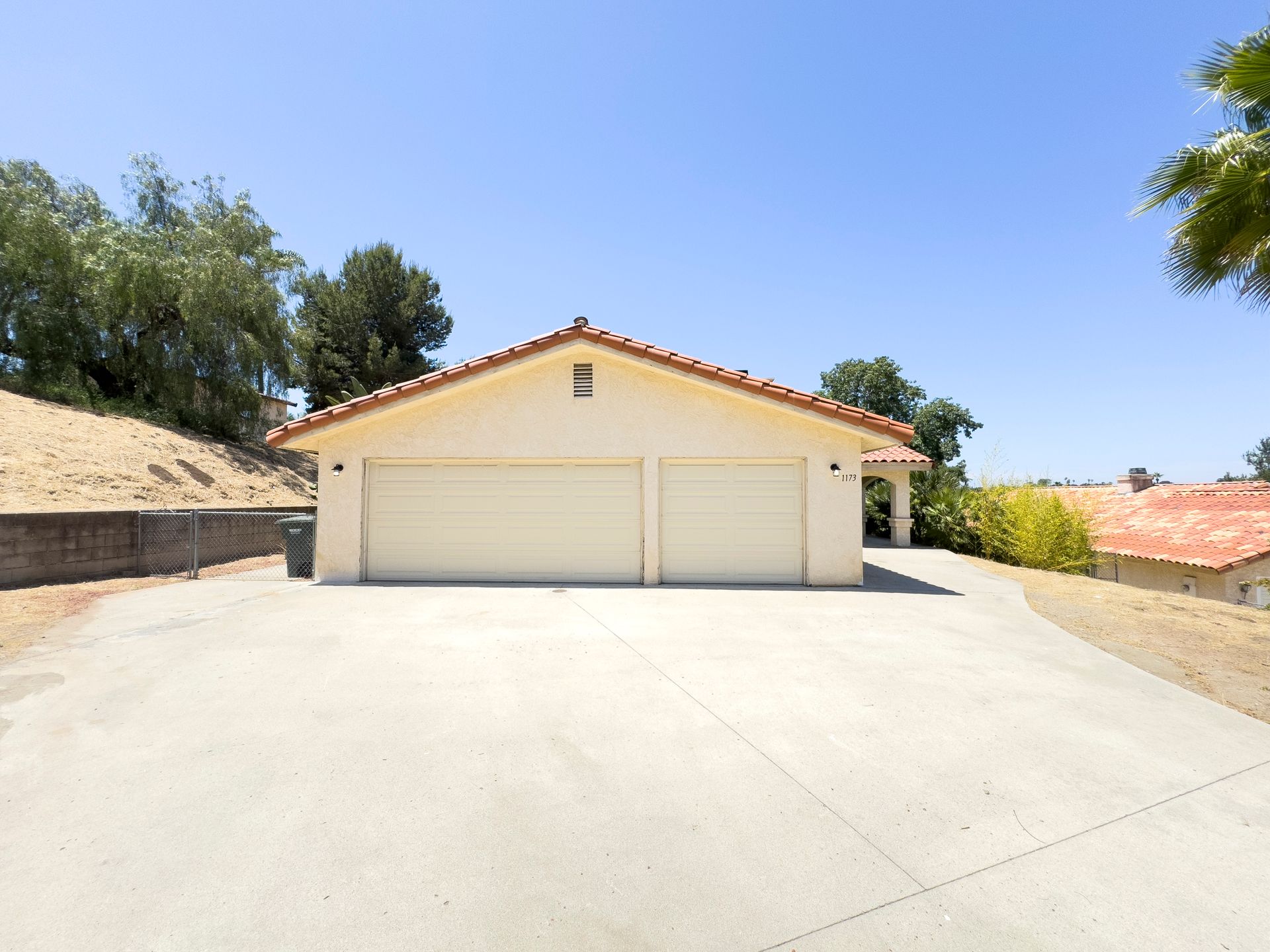 A white garage with a tiled roof and a driveway