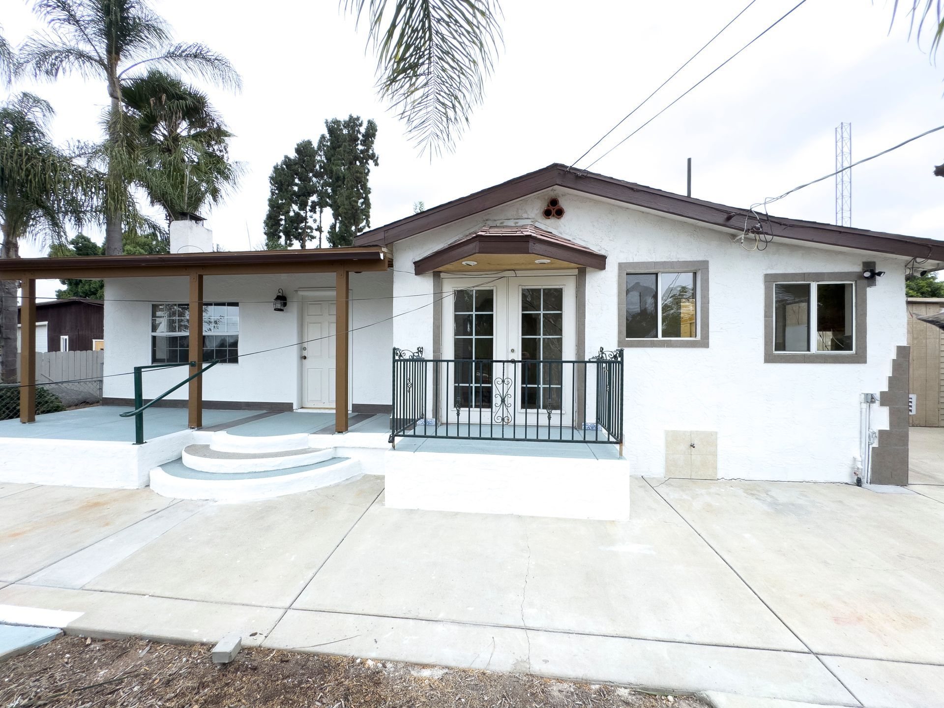 A white house with a porch and stairs in front of it