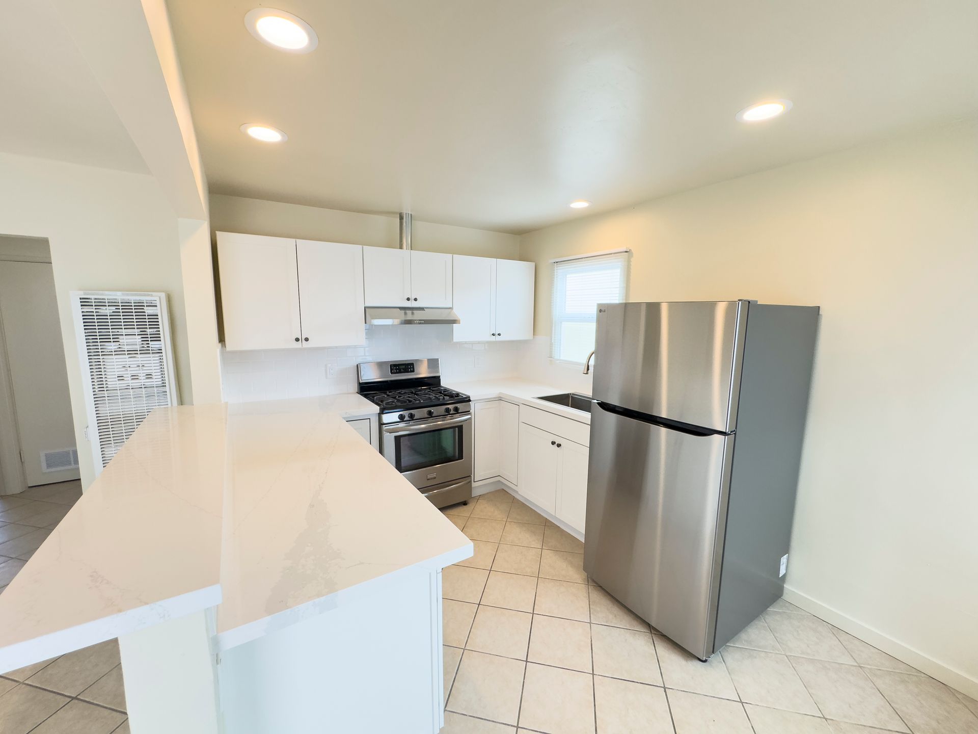 A kitchen with stainless steel appliances and white cabinets