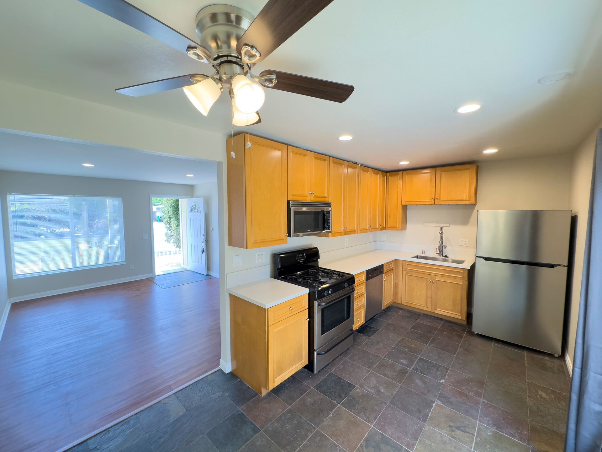 A kitchen with stainless steel appliances and a ceiling fan