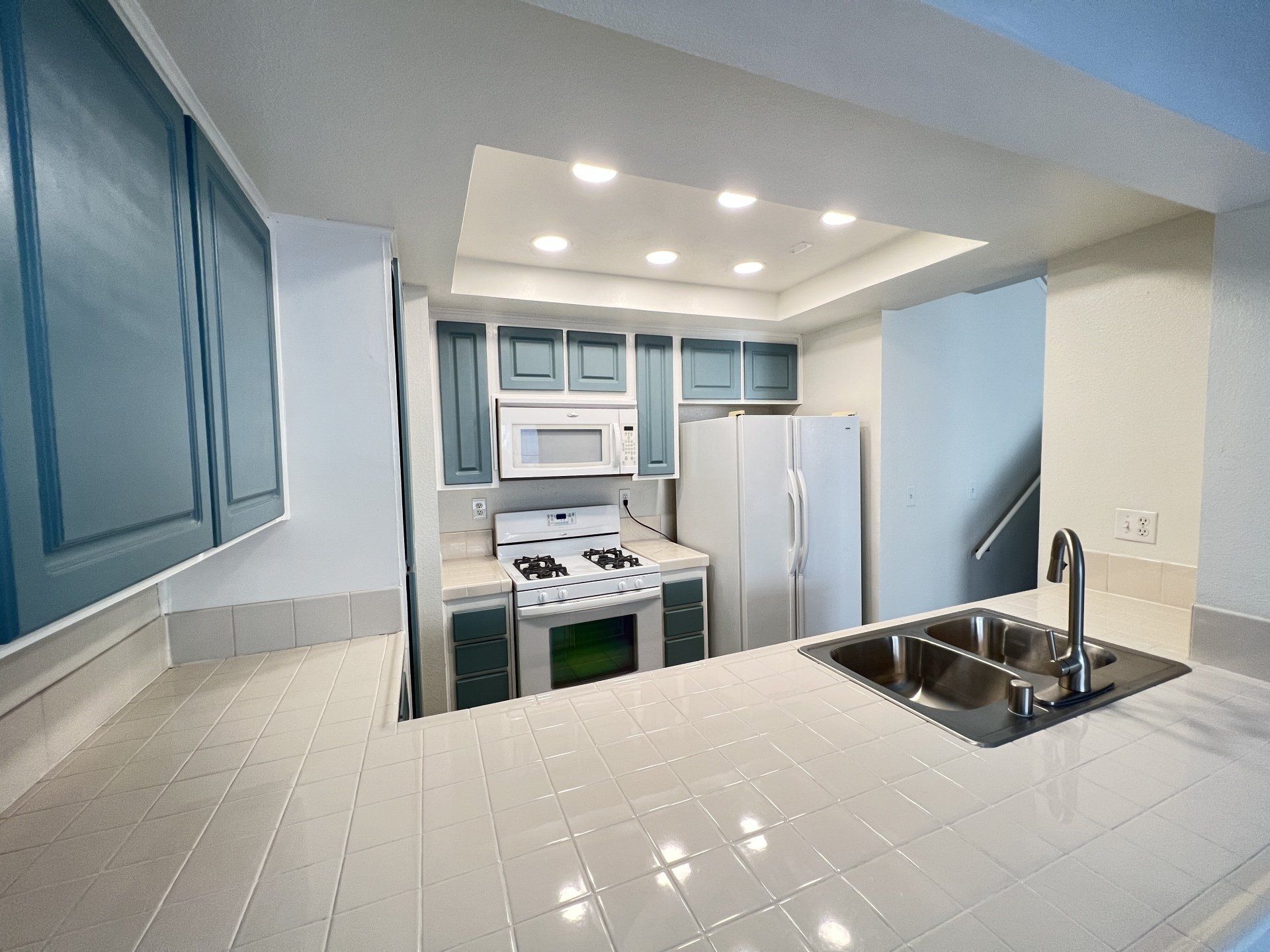 A kitchen with a stove a sink and a refrigerator