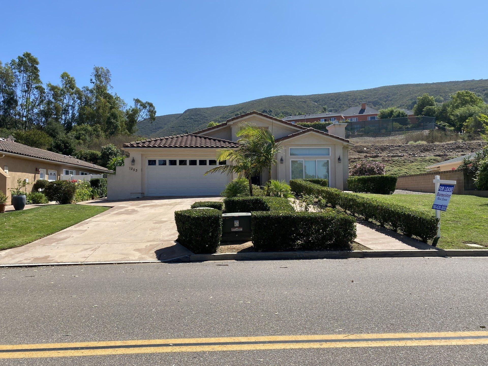 A house with a for sale sign in front of it.