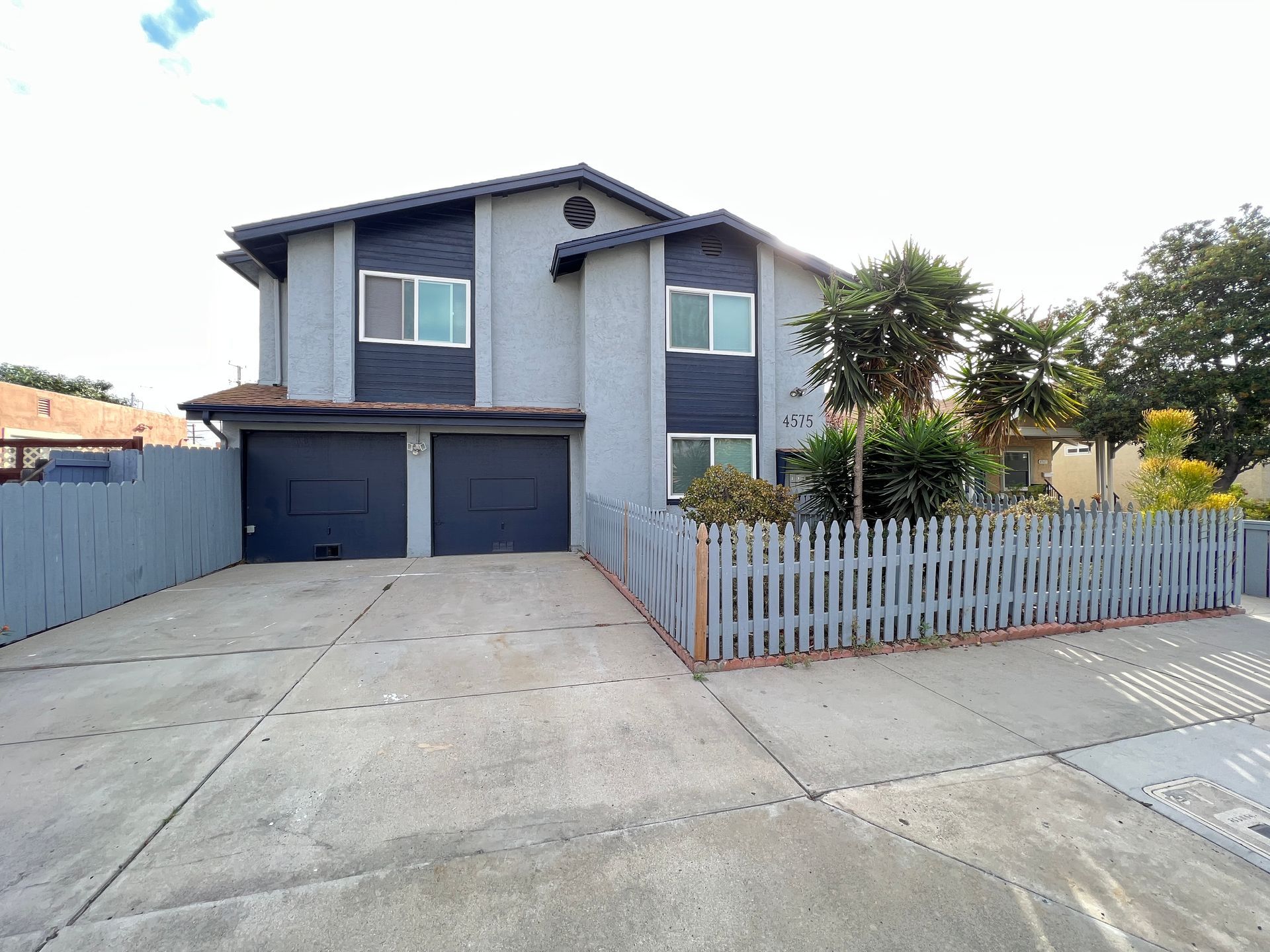A large house with a driveway and a fence around it