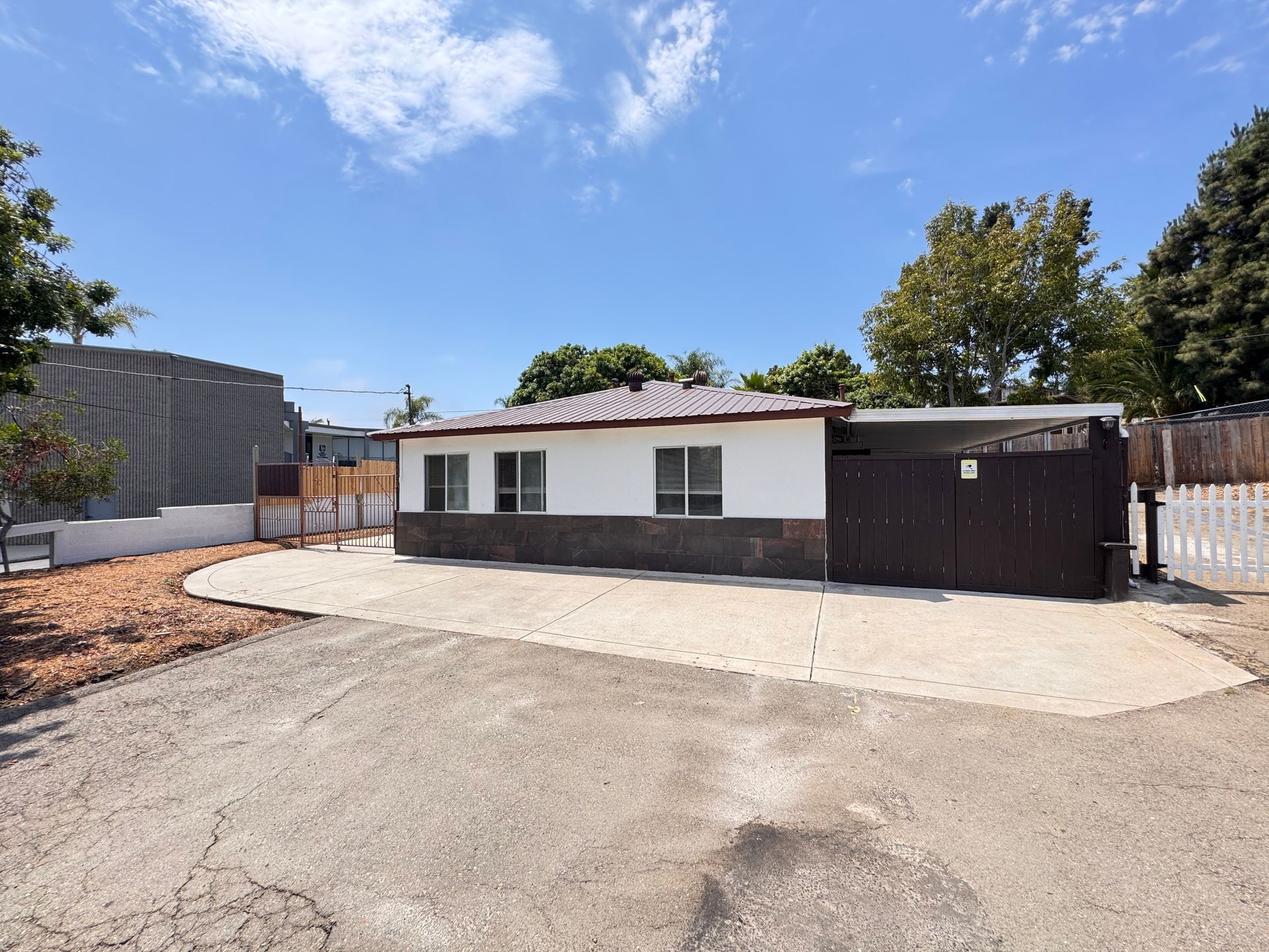 A white house with a brown fence in front of it