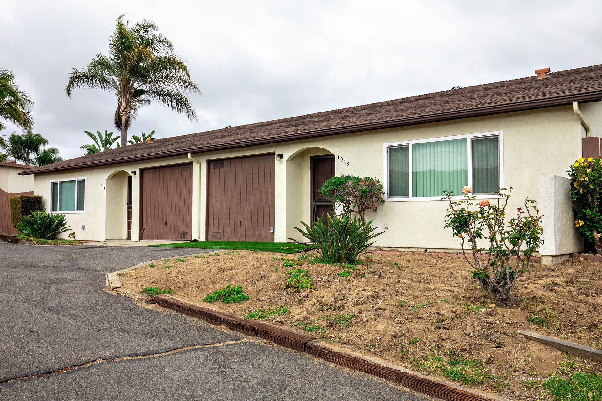 A white house with a palm tree in the background