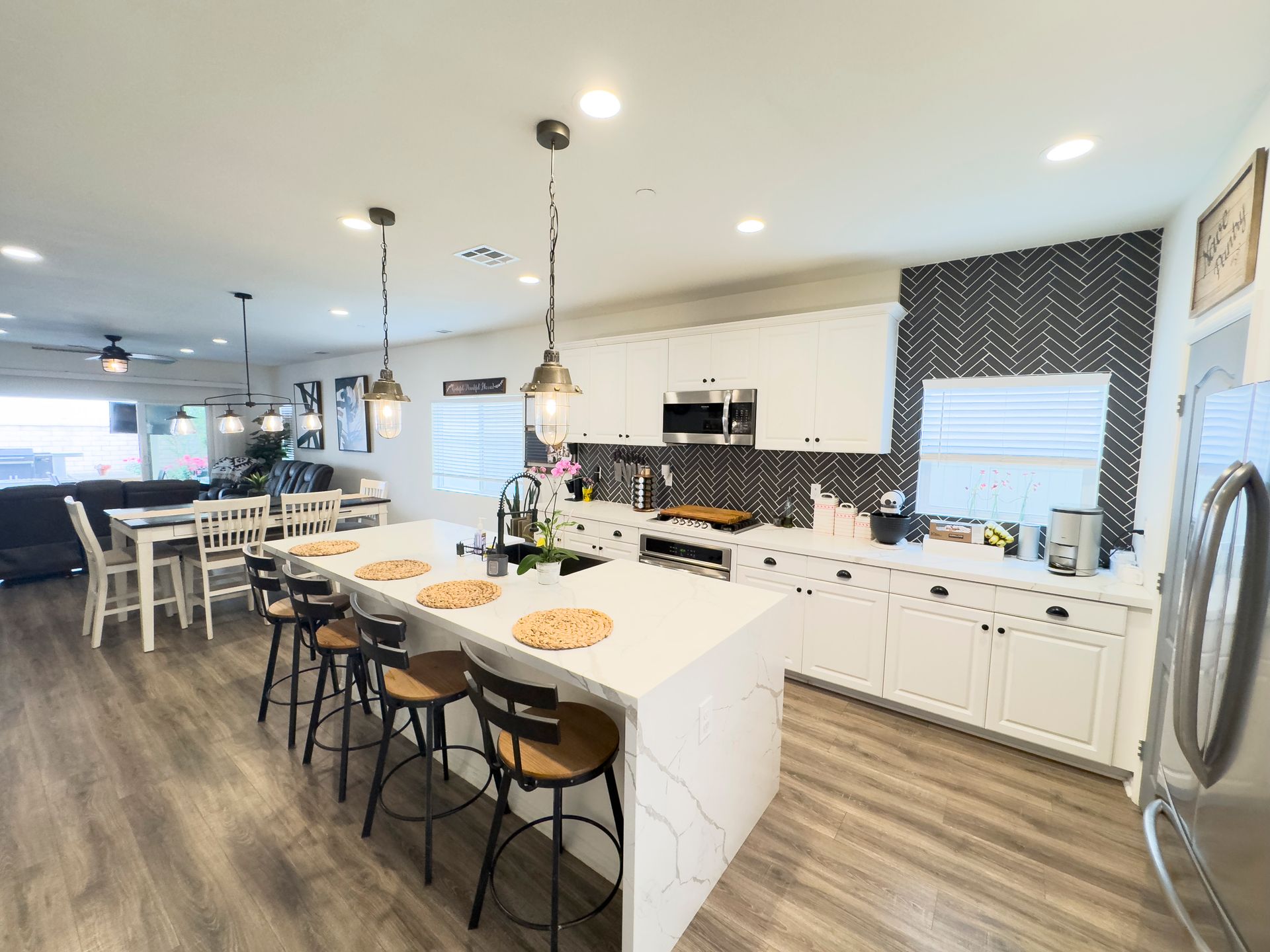 A kitchen with white cabinets and stainless steel appliances and a large island.