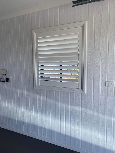 A White Wall With a Window With Shutters on It — Tamworth Blinds & Awnings in Gunnedah, NSW