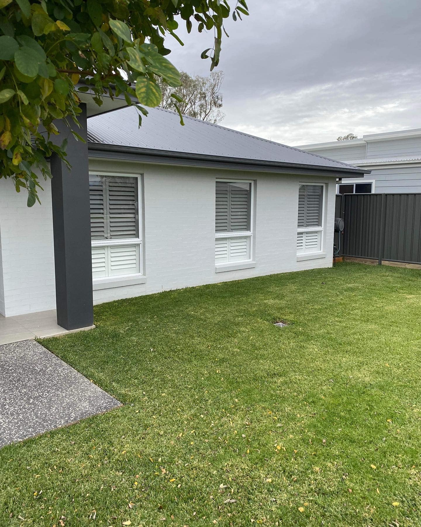White Home and Locally Made Grey Shutters on Windows — Tamworth Blinds & Awnings in Tamworth, NSW