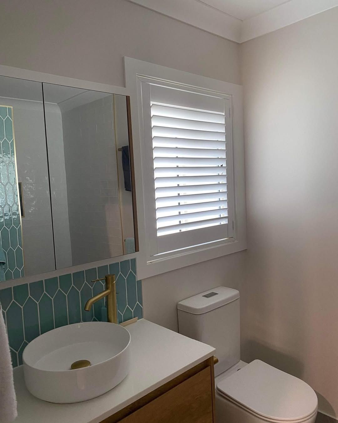 A Bathroom With a Sink Toilet Mirror and Window — Tamworth Blinds & Awnings in Quirindi, NSW