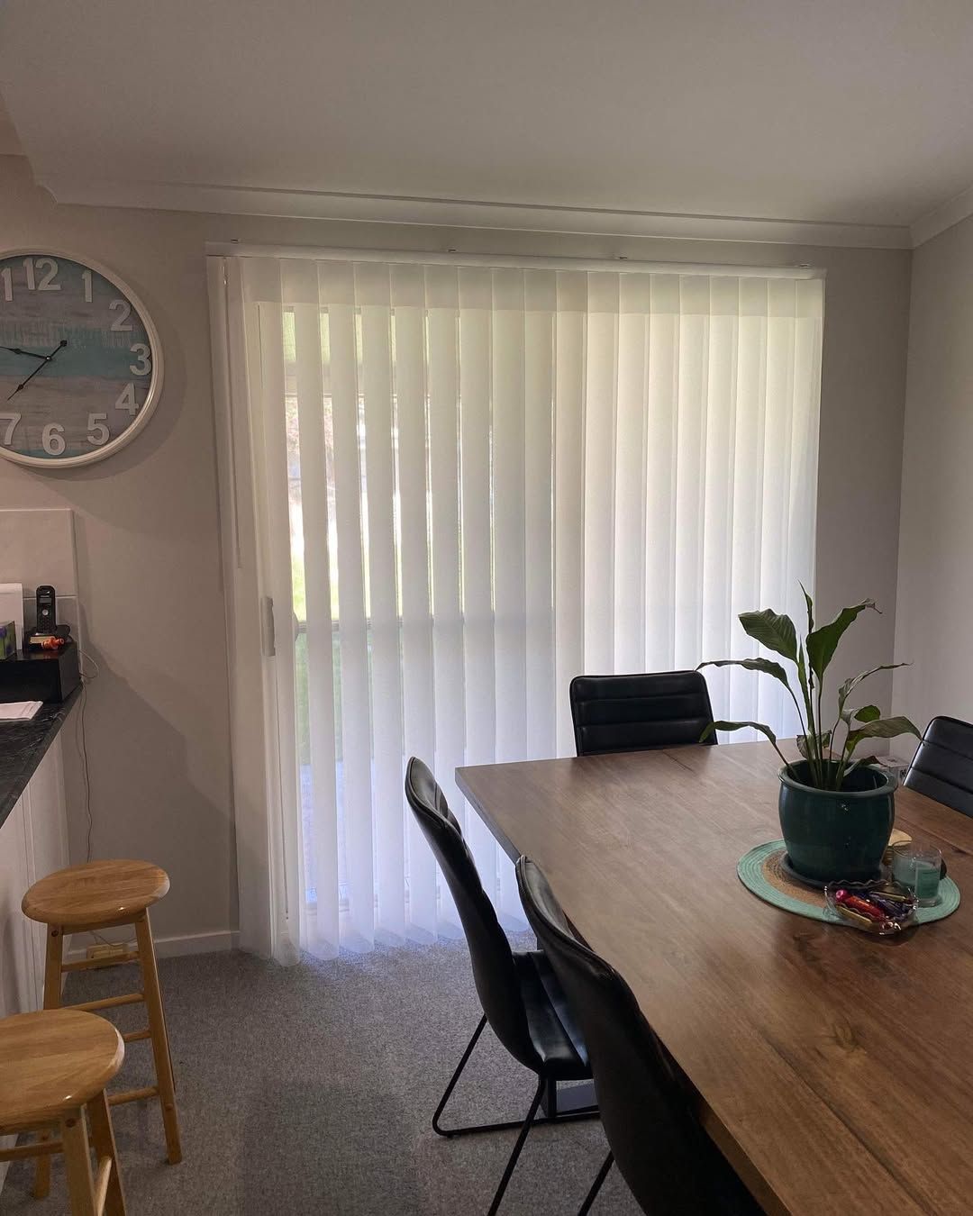 A Dining Room With a Table and Chairs and a Clock on the Wall — Tamworth Blinds & Awnings in Quirindi, NSW