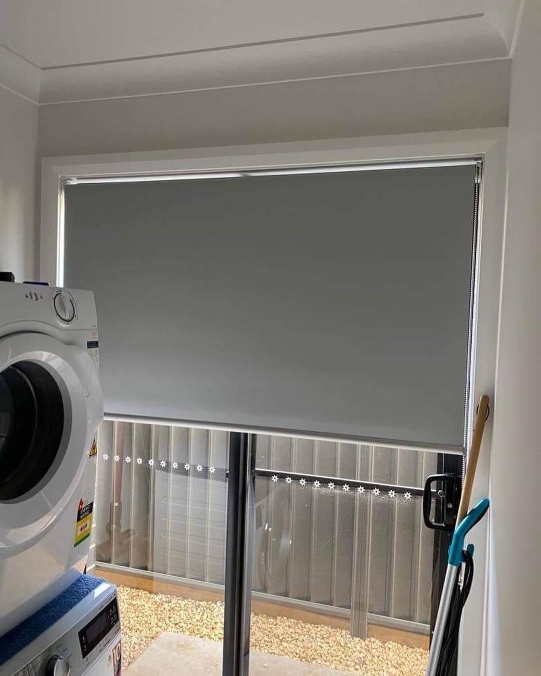 A Laundry Room With a Washing Machine and a Sliding Glass Door With Minimalist Awning — Tamworth Blinds & Awnings in Narrabri, NSW