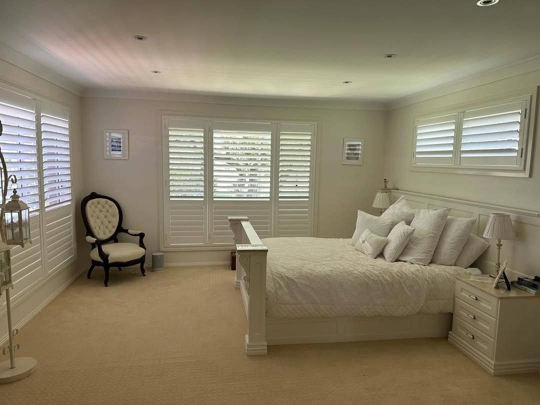 A Bedroom With a Bed and Shutters on the Large Windows — Tamworth Blinds & Awnings in Walcha, NSW