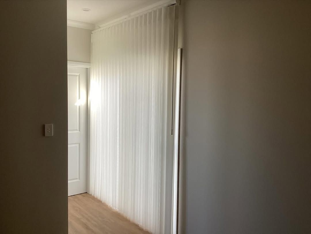 A Hallway With White Blinds on the Wall and a Door — Tamworth Blinds & Awnings in Tamworth, NSW