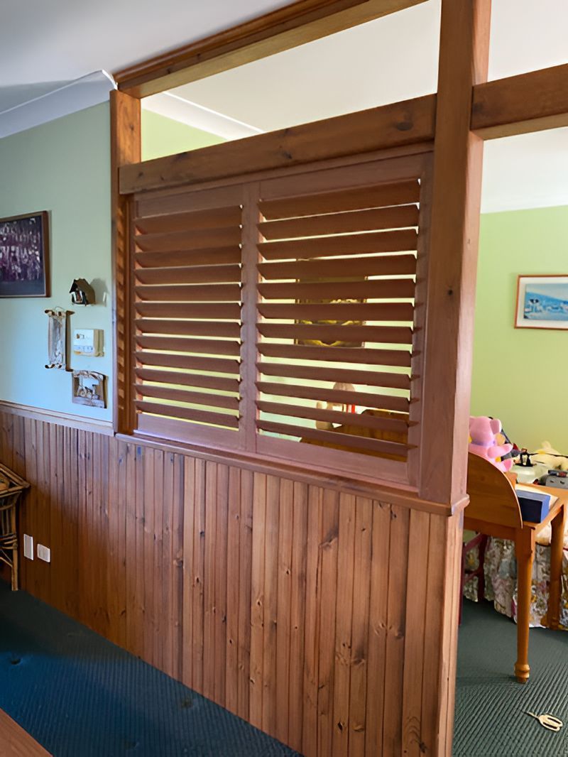 A Room With a Wooden Wall and Shutters on the Windows — Tamworth Blinds & Awnings in Gunnedah, NSW