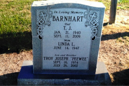 A gray stone monument inscribed with the Barnhart family name and details for T.J., Linda L., and Troy Joseph Barnhart.