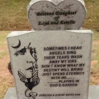 A headstone engraved with Stevie Nicks lyrics, a portrait of the singer, and the text, 