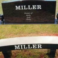 A black granite bench and monument in a grassy setting, both inscribed with the name MILLER.