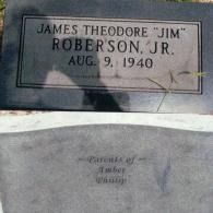 A black granite headstone with the name James Theodore 