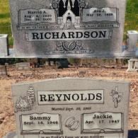 Two gray stone grave markers in a cemetery with the family names Richardson and Reynolds and their marriage dates.
