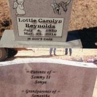 A gray granite tombstone for Lottie Carolyn Reynolds, dated 1950–2016, listing her family members below.