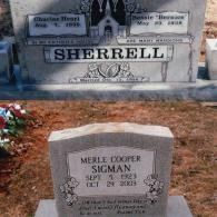 Two grey granite grave markers in a cemetery. The larger one is inscribed 