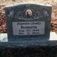 A gray stone grave marker for Joyette (Jodi) Roberts, born Aug. 27, 1949, and died Dec. 6, 2014, with prayer hands etched.
