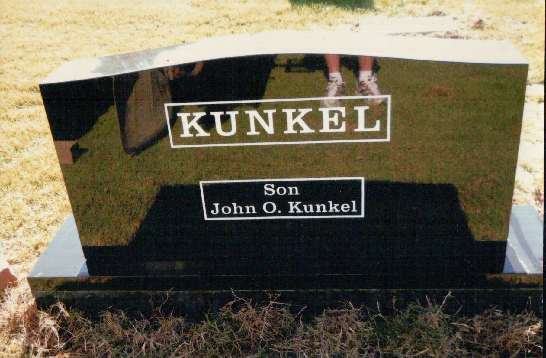 A black granite headstone with the name 