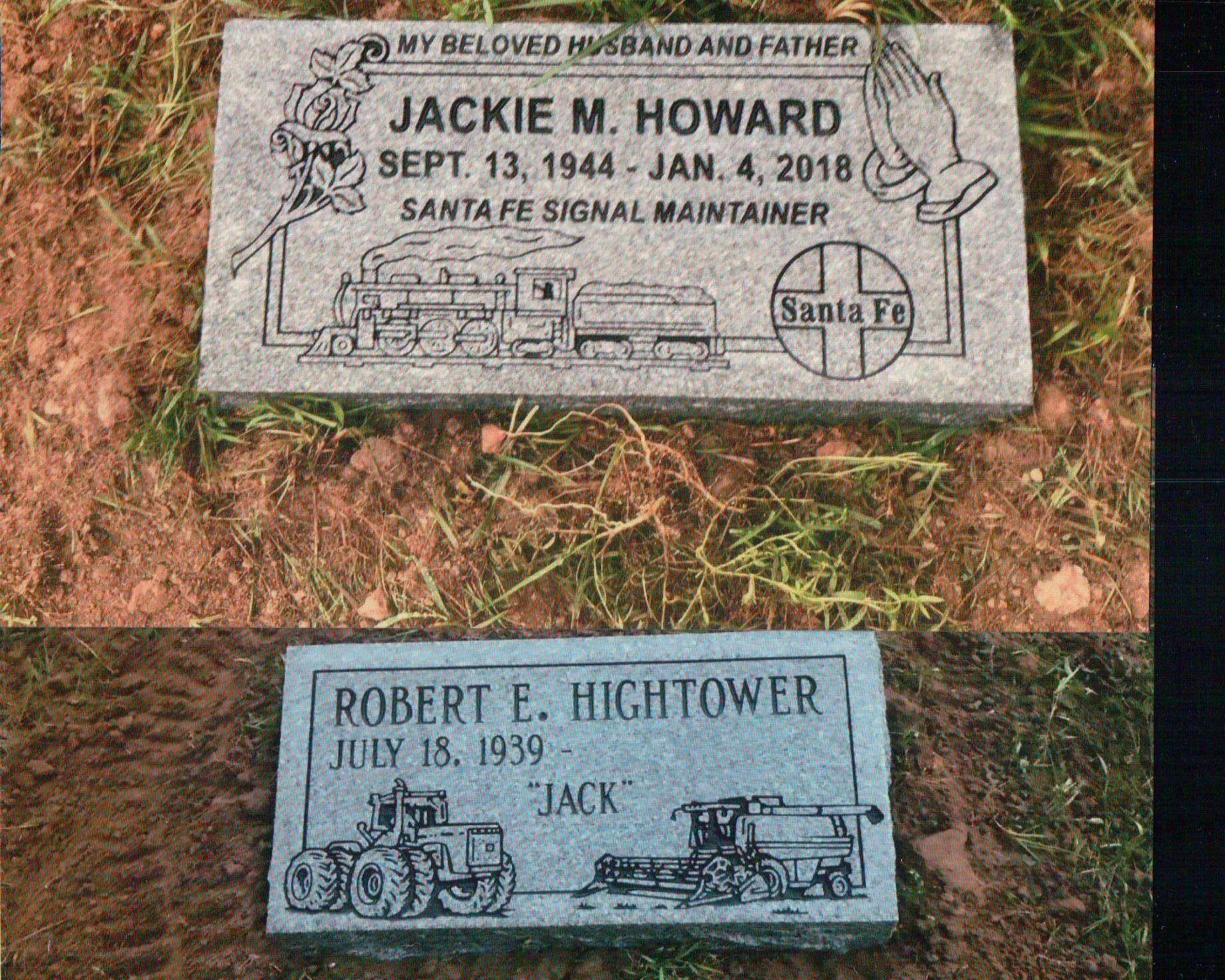 Two granite grave markers on grass; the top for Jackie M. Howard with a train, the bottom for Robert E. Hightower with a tractor.