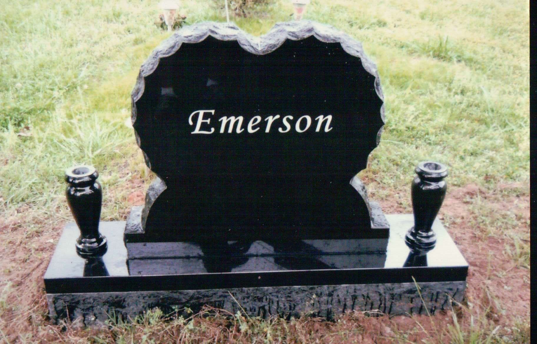 A black heart-shaped granite headstone with the name 