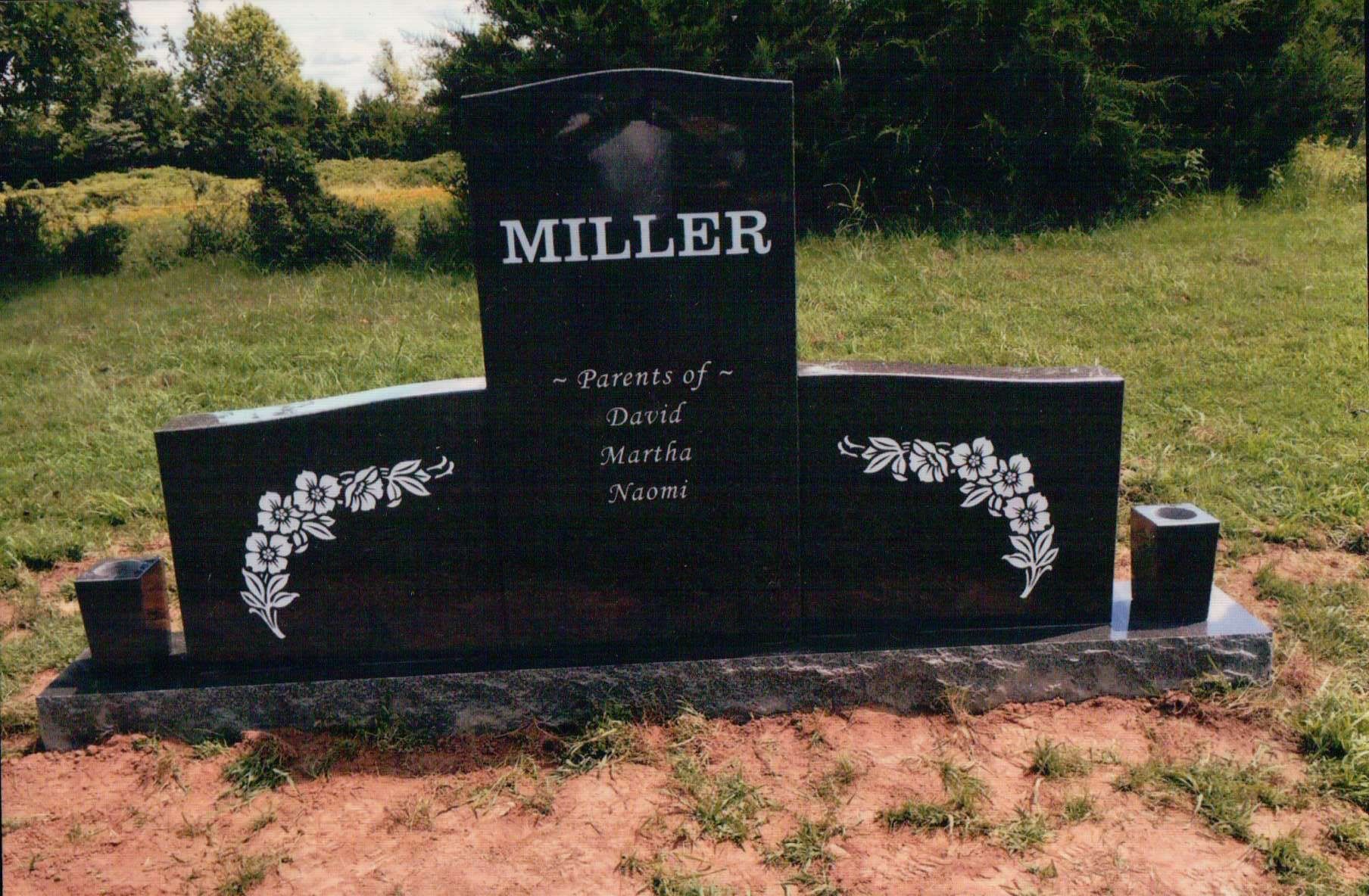 A polished black granite monument featuring the name 