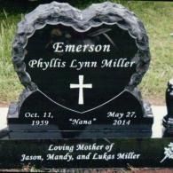 A black heart-shaped headstone for Phyllis Lynn Miller (1959–2014) engraved with a cross and 