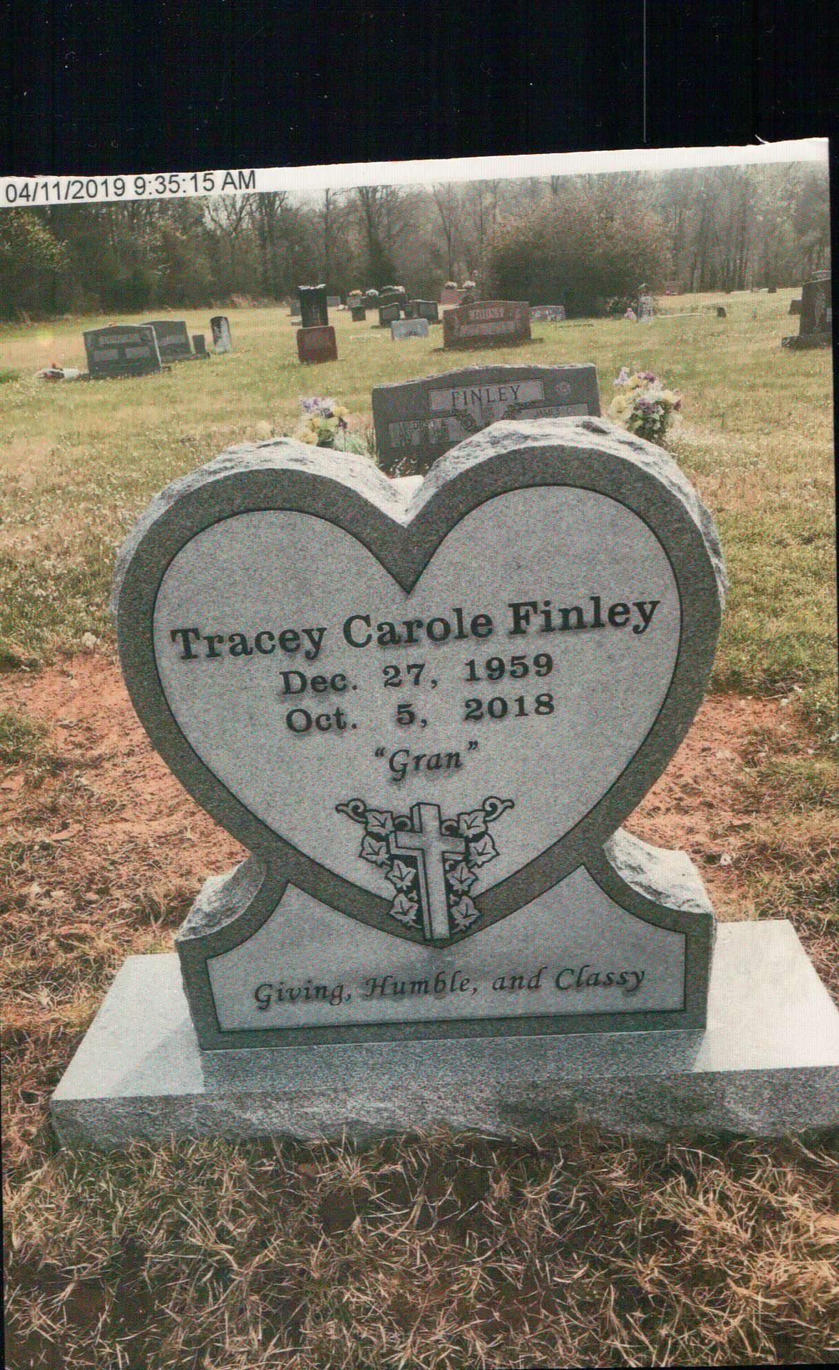 A heart-shaped gray granite headstone inscribed 