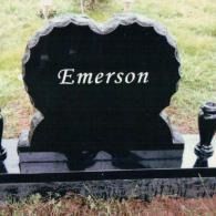 Black upright headstone with a scalloped top edge, engraved with the name 