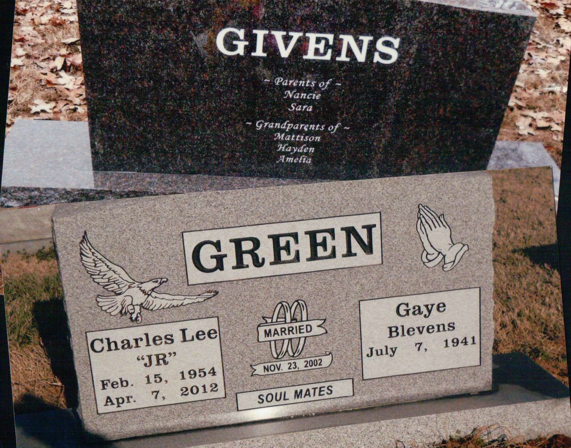 Two granite headstones: one labeled GIVENS, and one labeled GREEN with names, dates, and symbols like an eagle and hands.