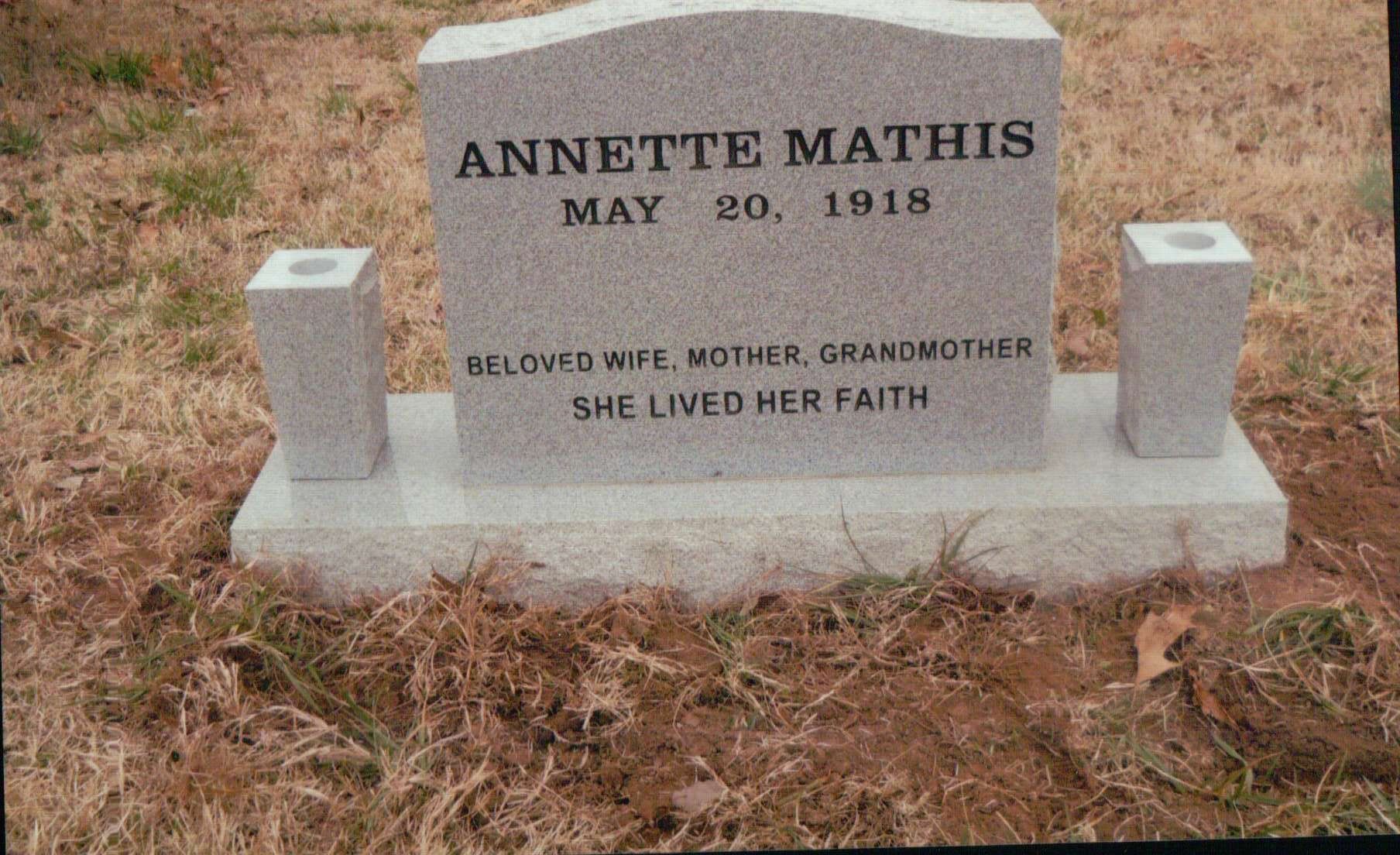 A grey granite headstone for Annette Mathis, inscribed with her birth date, 