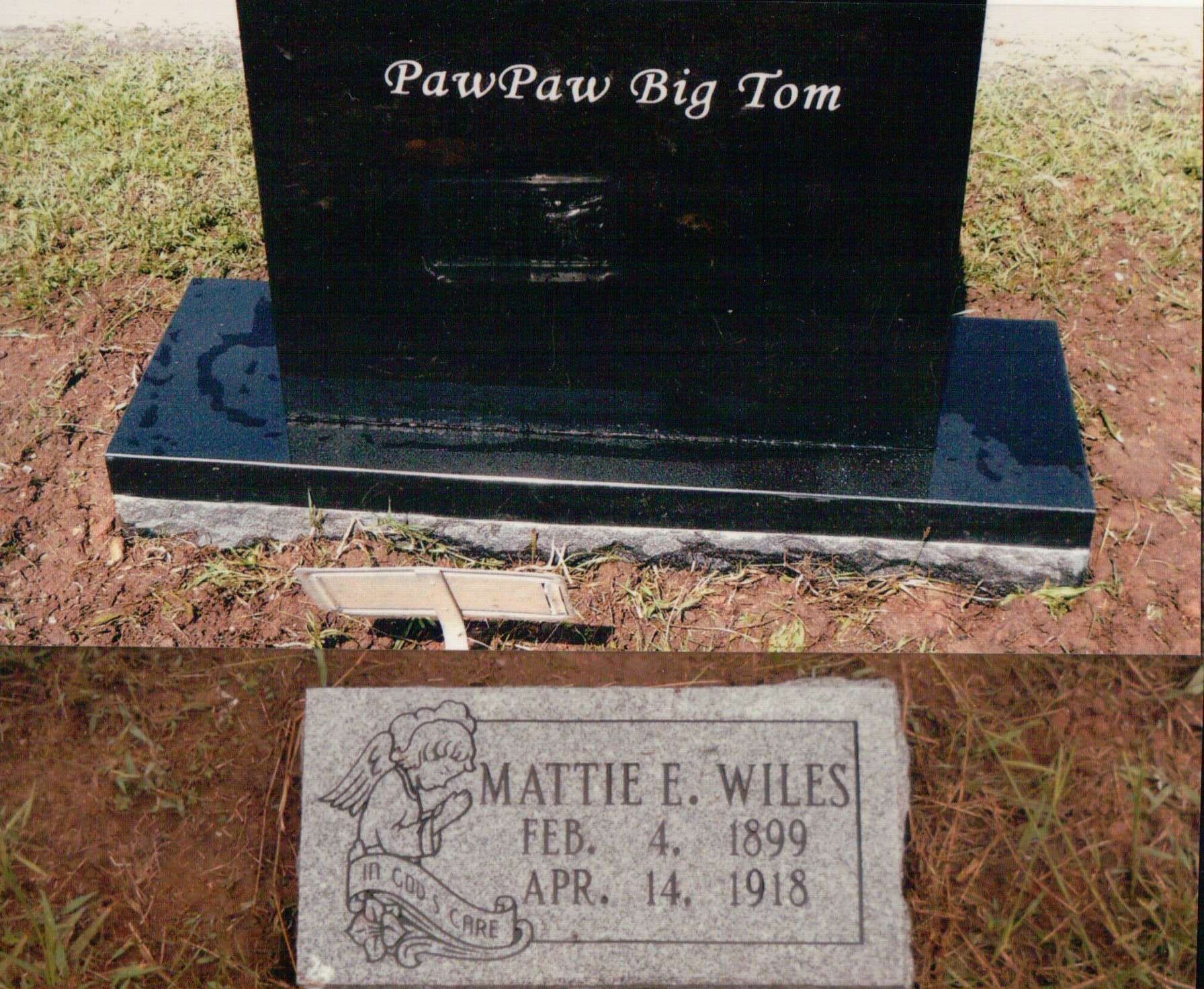A large black upright headstone inscribed 