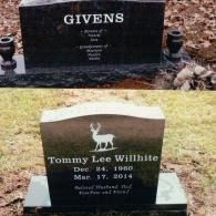 Two black granite grave markers on grass; one with 