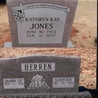 Two gray granite headstones in a cemetery; one inscribed with Kathryn Kay Jones and the other with the surname Herren.