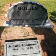Two gravestones in a grassy cemetery: a large upright monument reading 