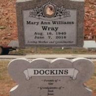 Two gray granite grave markers in a cemetery. One is inscribed 