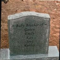 A gray stone grave marker inscribed 