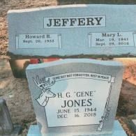 Two gray granite headstones in a cemetery; one inscribed 