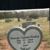 A heart-shaped gray granite headstone for Tracey Carole Finley, dated 1959–2018, in a cemetery.